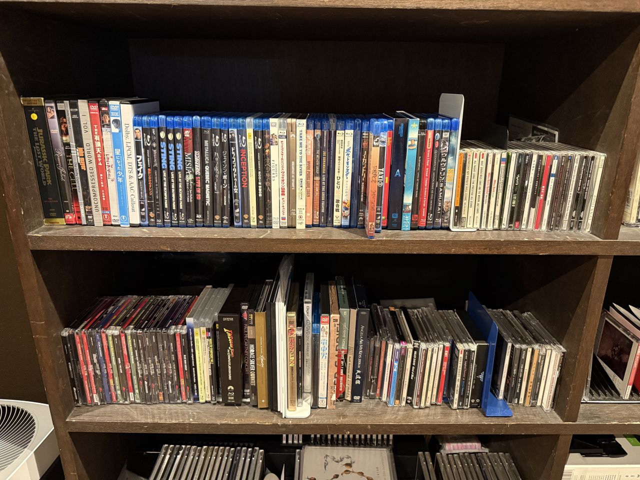Two shelves full of Blu-ray discs (and some CDs and DVDs)