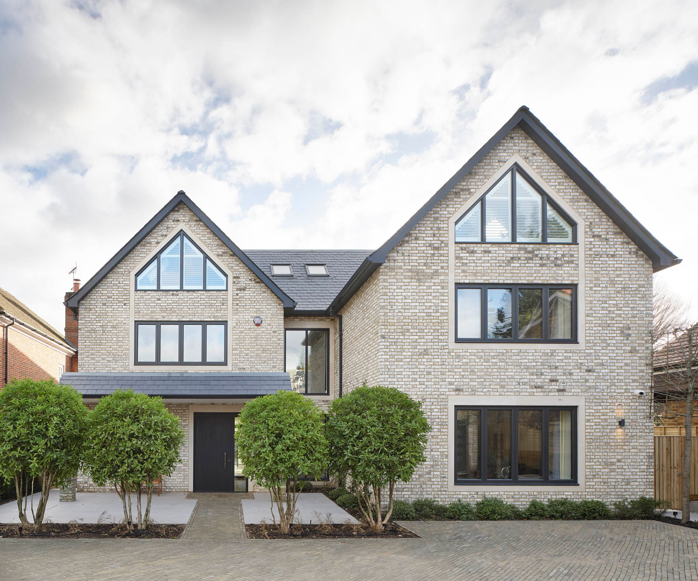 white brick contemporary house with block paved driveway