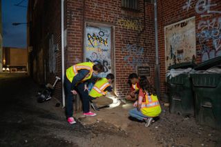 Jonathan Richardson surveying a rat infestation with students.