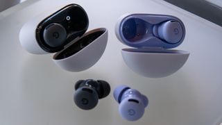 Pixel Buds 2a earbuds in Hazel and Iris next to their cases