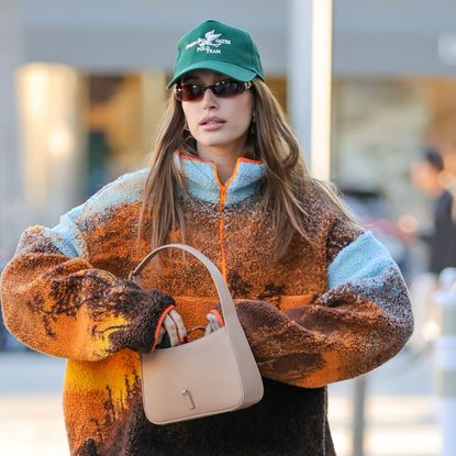 Hailey Bieber out walking in a fleece and cap