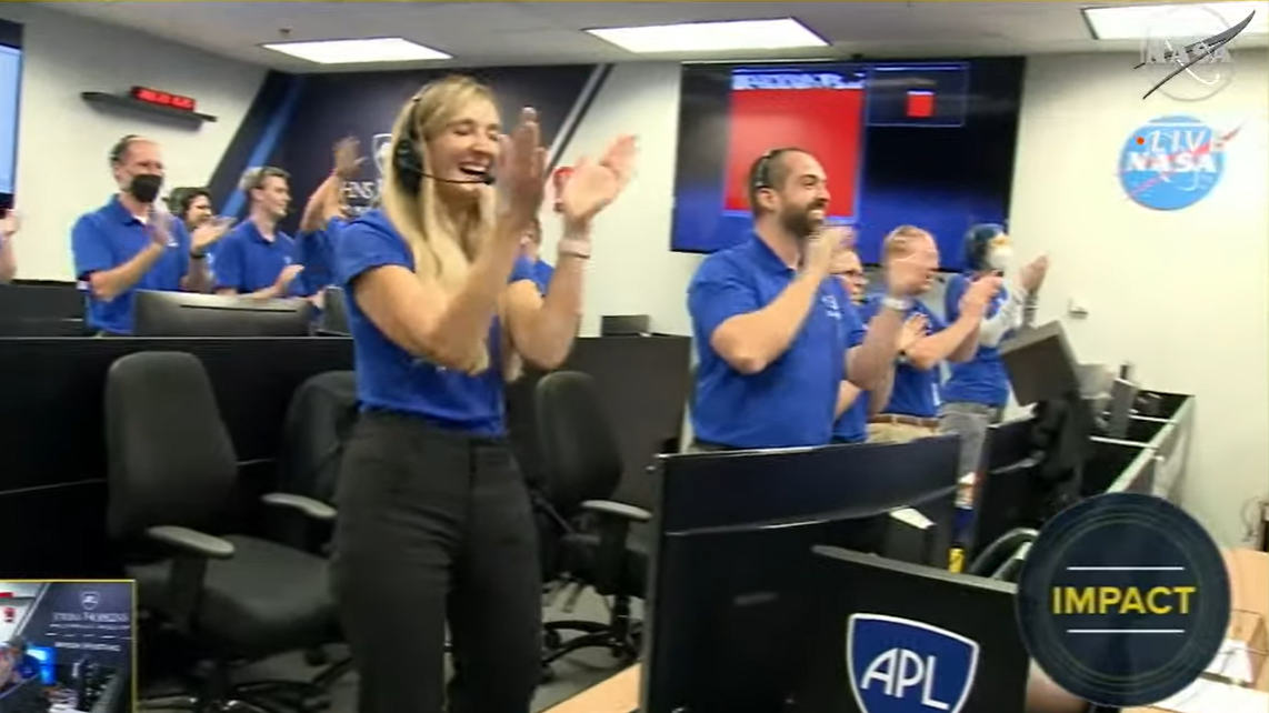 people in blue shirts standing and clapping