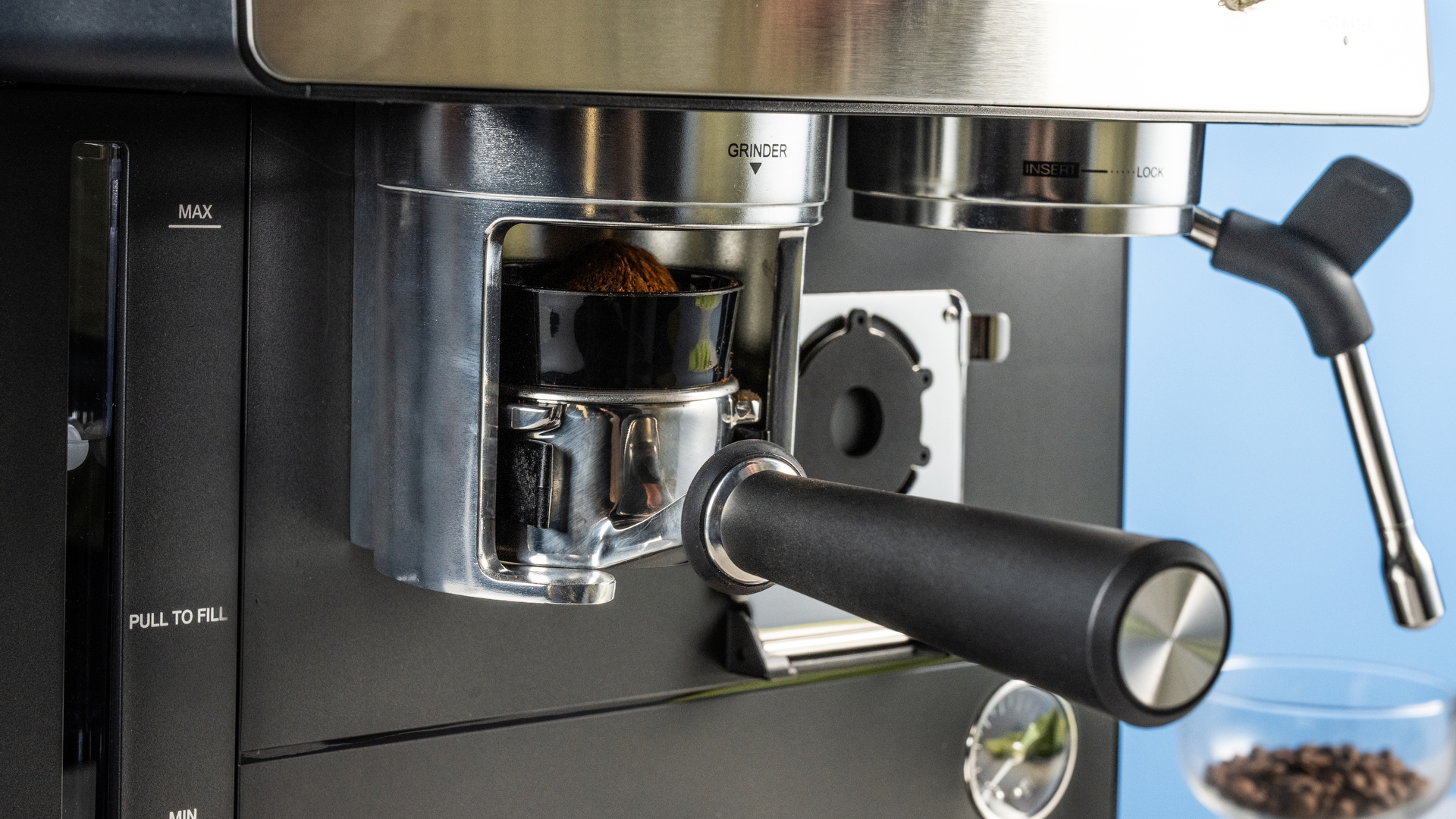 the cuisinart grind, tamp and brew espresso machine with built-in grinder photographed against a blue tom's guide background