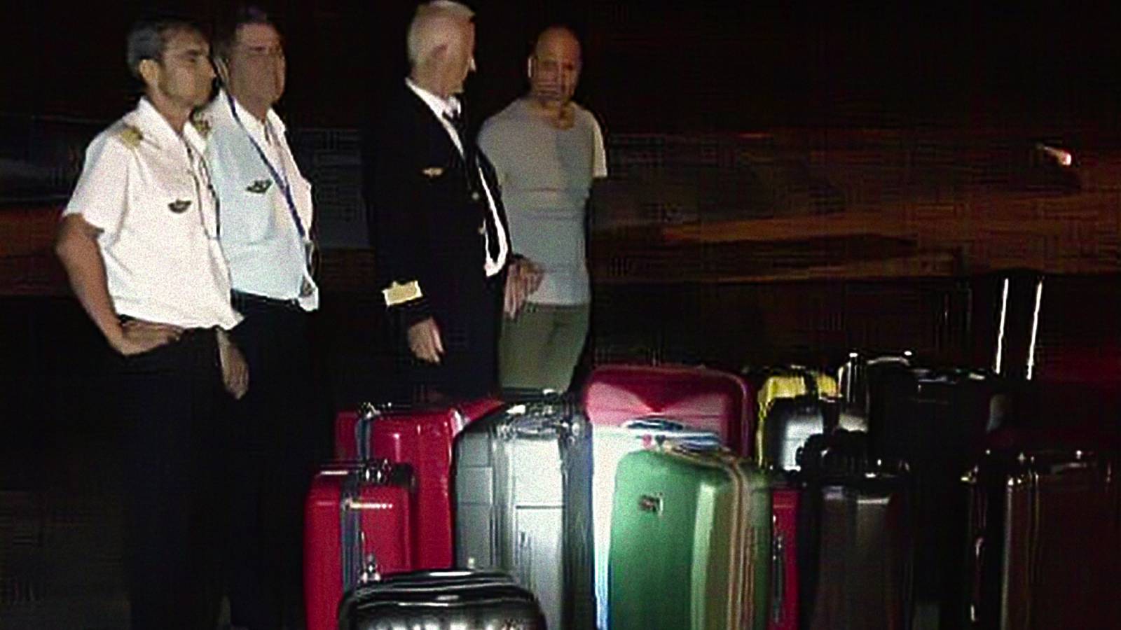 An archival picture from Netflix's Cocaine Air: Smugglers at 30,000 Ft. showing pilots in front of a huge number of suitcases.