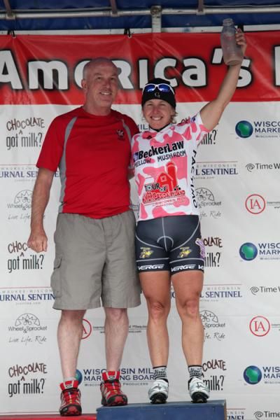 Laura Van Gilder stands atop the podium with the pink leaders jersey.