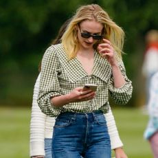 Sophie Turner wears a Peter Pan collar shirt with jeans to a polo match
