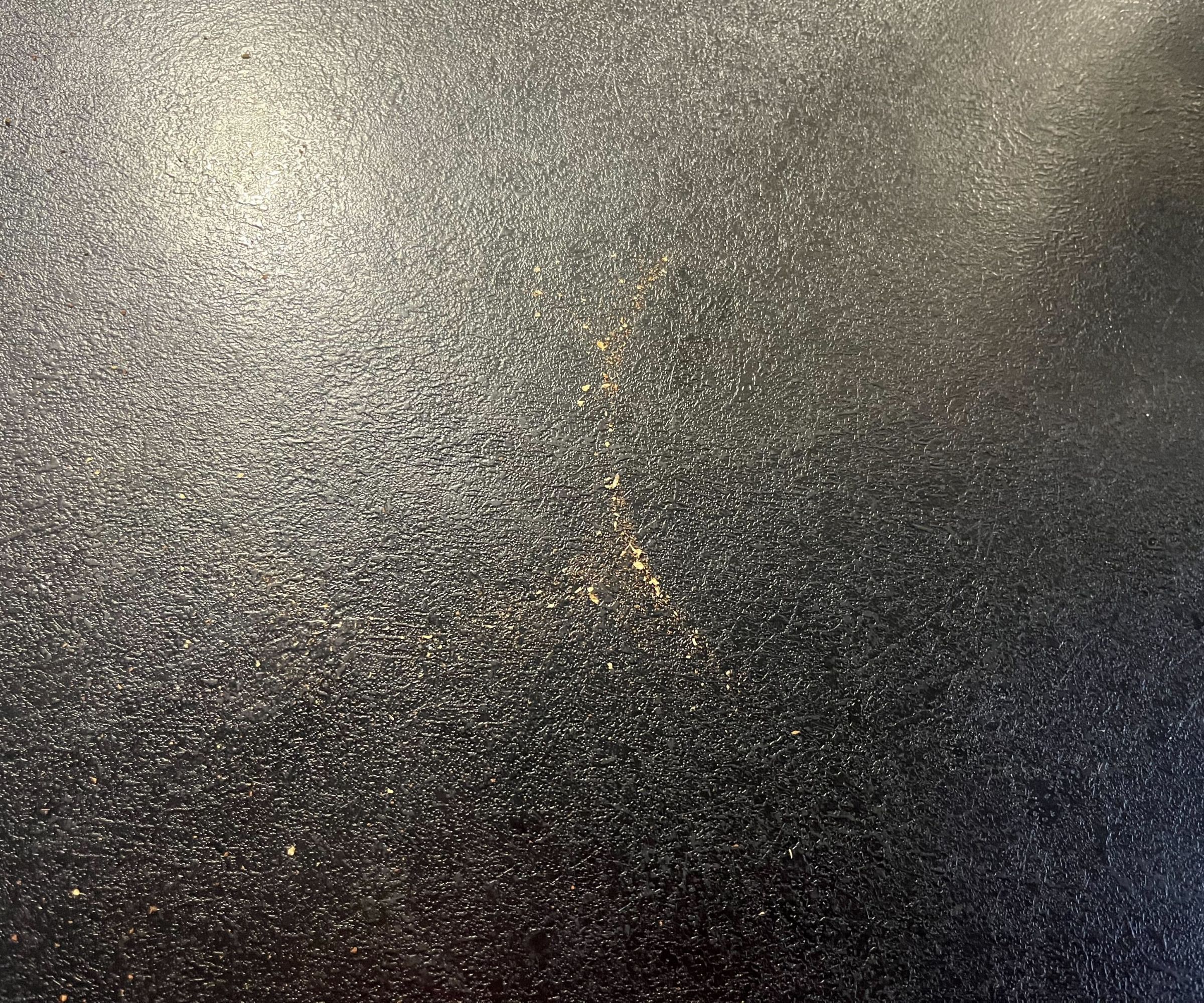 Some coffee round dust on a black kitchen counter