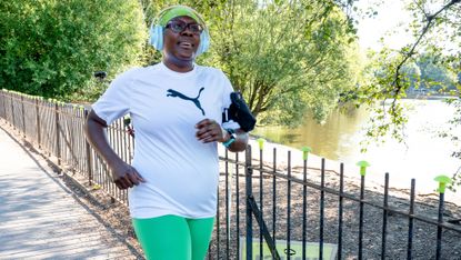 A runner in a park wearing over-the-ear headphones