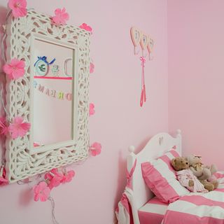 bedroom with pink walls and pink with white striped bedding set