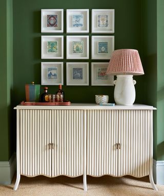 green living room with cabinet in an alcove with wall art and vignette styling