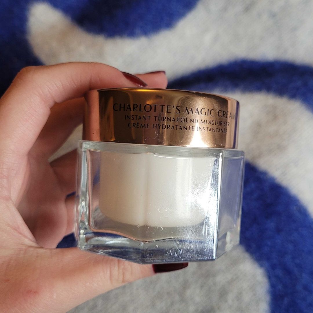 Hand holding Charlotte Tilbury Magic Cream