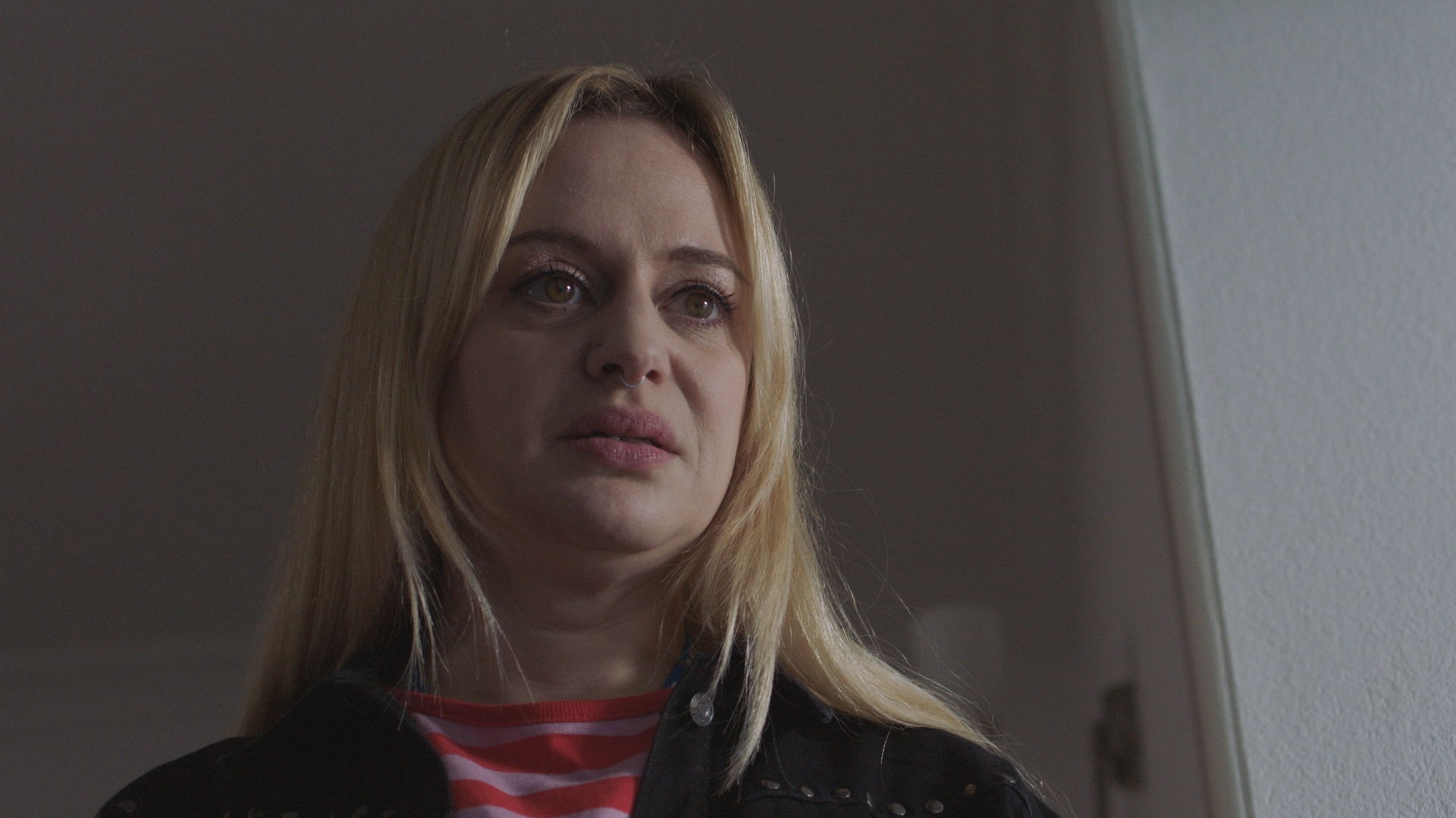 Nicole standing in Tina&#039;s house looking upset.