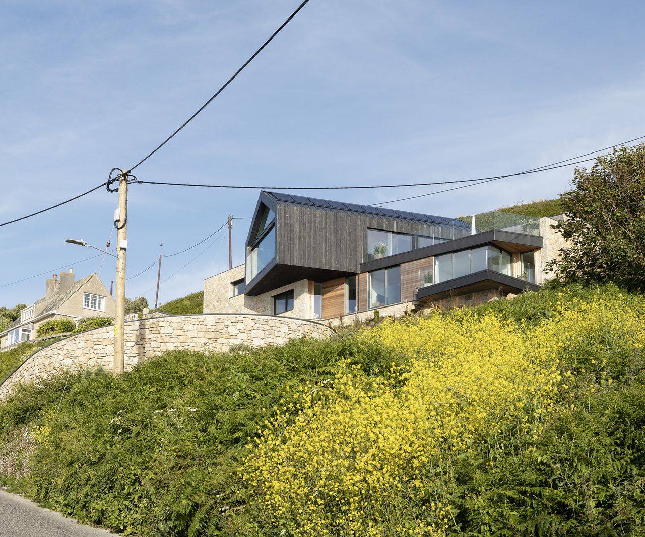 A cantilever self build home build on a cliffside clad in timber