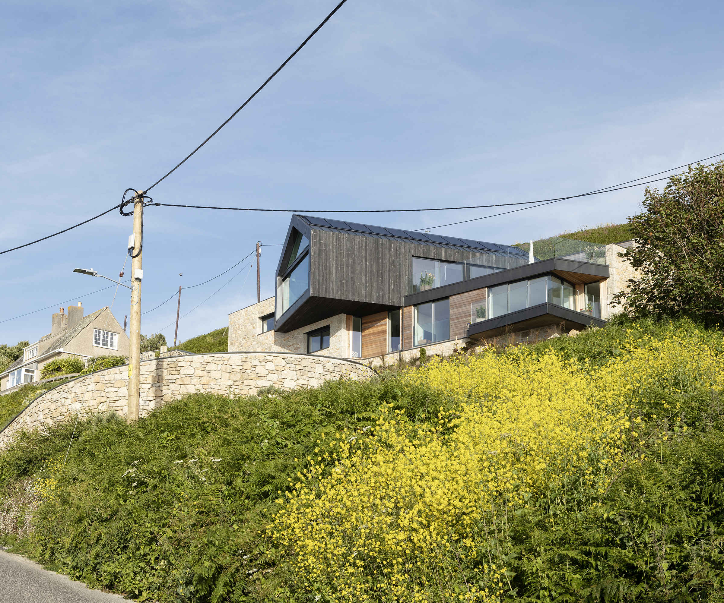 A cantilever self build home build on a cliffside clad in timber