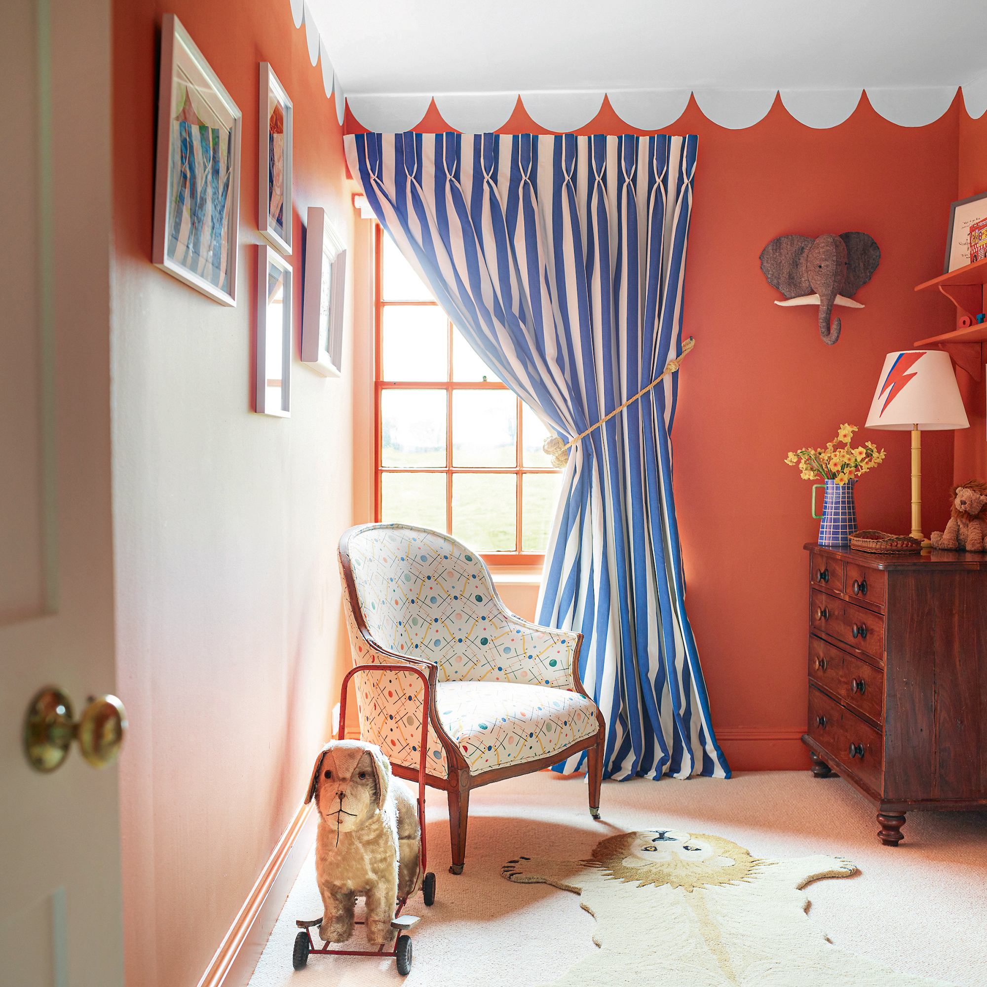 childrens bedroom with orange walls, pelmet paint detail at top and circs theme