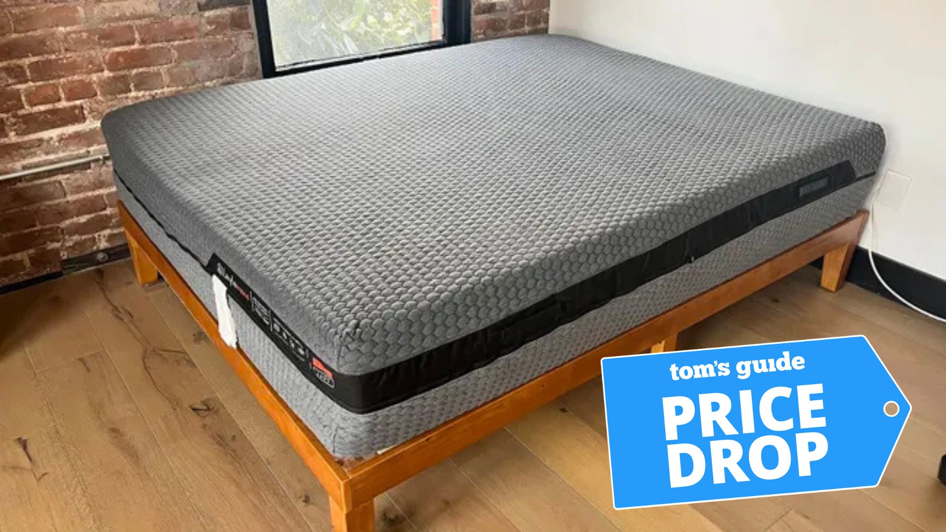 The Layla Hybrid mattress in a brightly-lit bedroom. There is a price drop deals badge in the bottom right corner. 