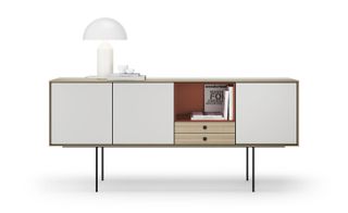 The 'Aura' sideboard, by Angel Martí and Enrique Delamo for Treku. White sideboard with cupboards, drawers and ornaments and is standing on thin black metal legs.
