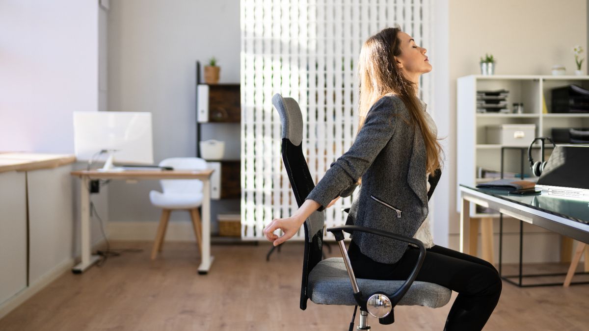 A woman stretching at her desk