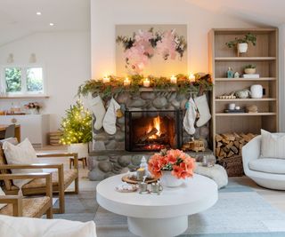 Living room space with holiday decor around mantel display and coffee table