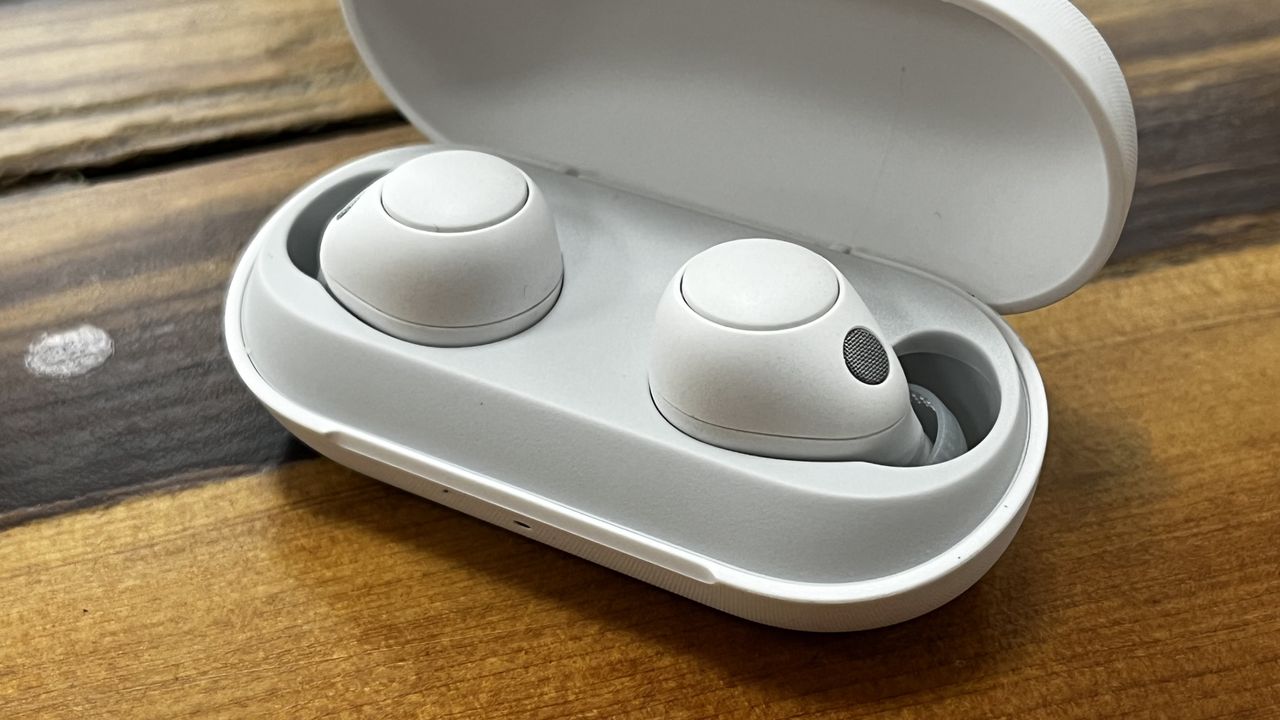 The Sony WF-C700N wireless earbuds in white, on a wooden background