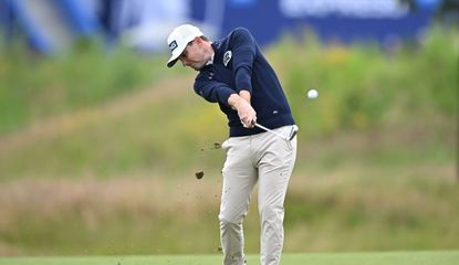  Joel Girrbach strikes an iron shot from the middle of the fairway