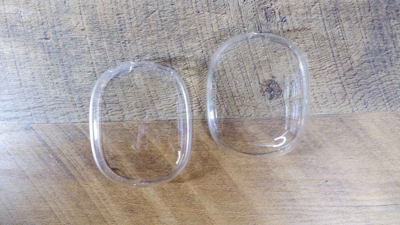 Clear Spigen AirPods Max earcup covers on a wooden floor