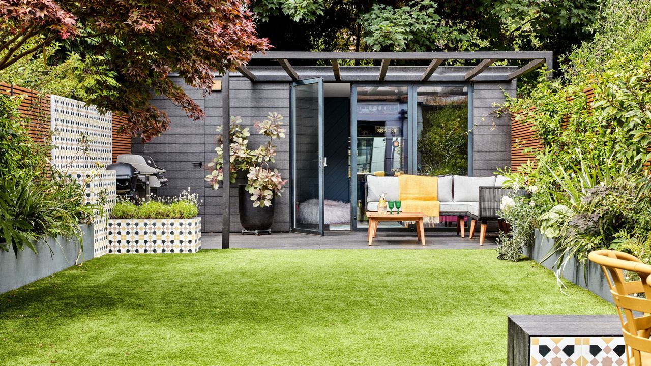 Garden shed with lawn surrounding, trees, plants in planters