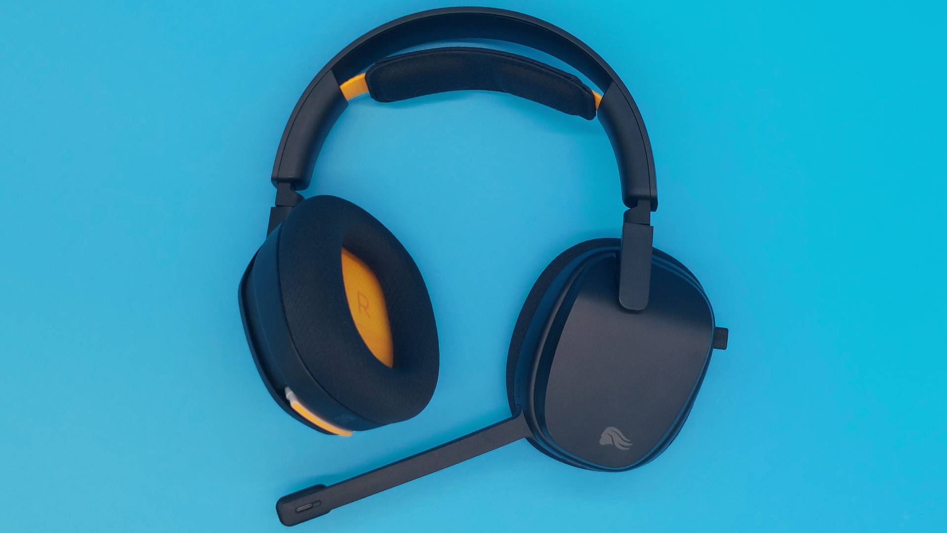 The GHS Wireless InfinitePlay seen from various angles on a blue background. This is a wireless gaming headset from Glorious. It is black all over, save for a few subtle orange accents.