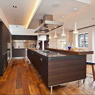 kitchen with white walls brown worktops and wooden flooring