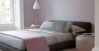 Lilac bedroom with bed with a cool ing mattress to demonstrate how to keep a bedroom cool in summer