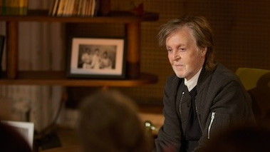 Paul McCartney, seated
