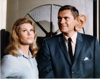 ELIZABETH MONTGOMERY and DICK YORK with an oversized ear in a still from the tv show bewitched