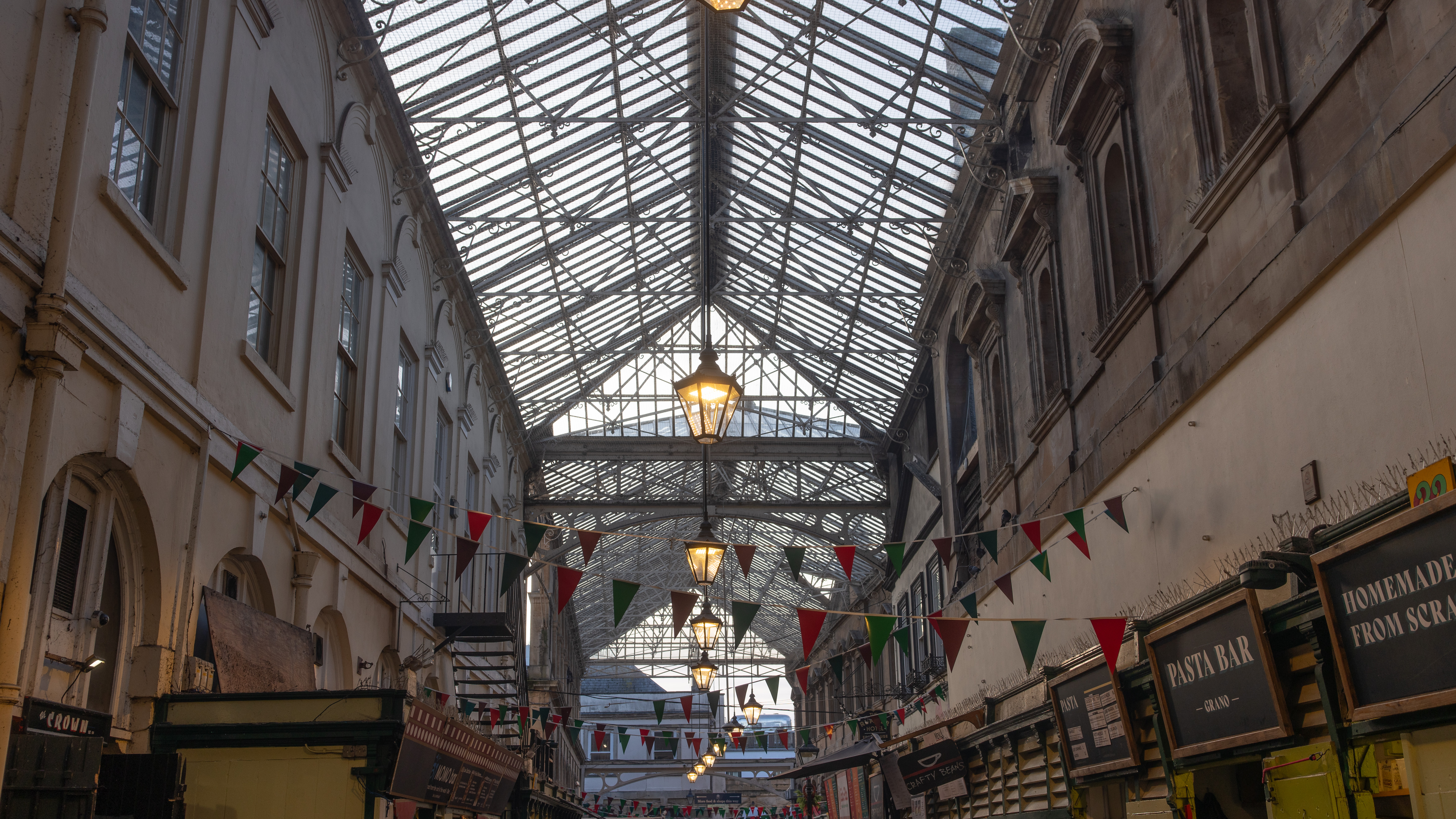 A wide-angle shot of St Nick's market in Bristol, showing market stands and the building's large central skylight.
