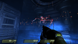 A giant red spiderbot stalks the player through a Strogg facility