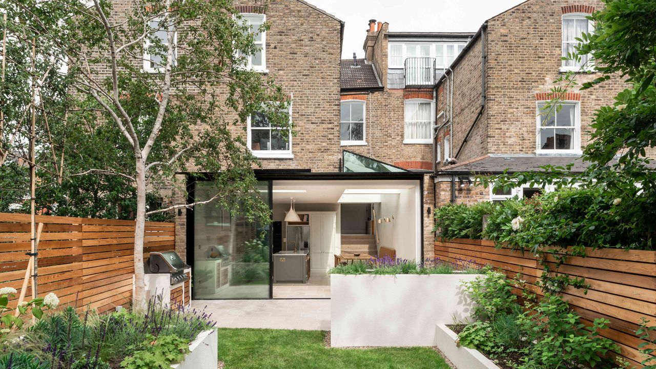 Dropping the floor level view from a garden into an extended property with sliding doors and an open plan kitchen diner inside 