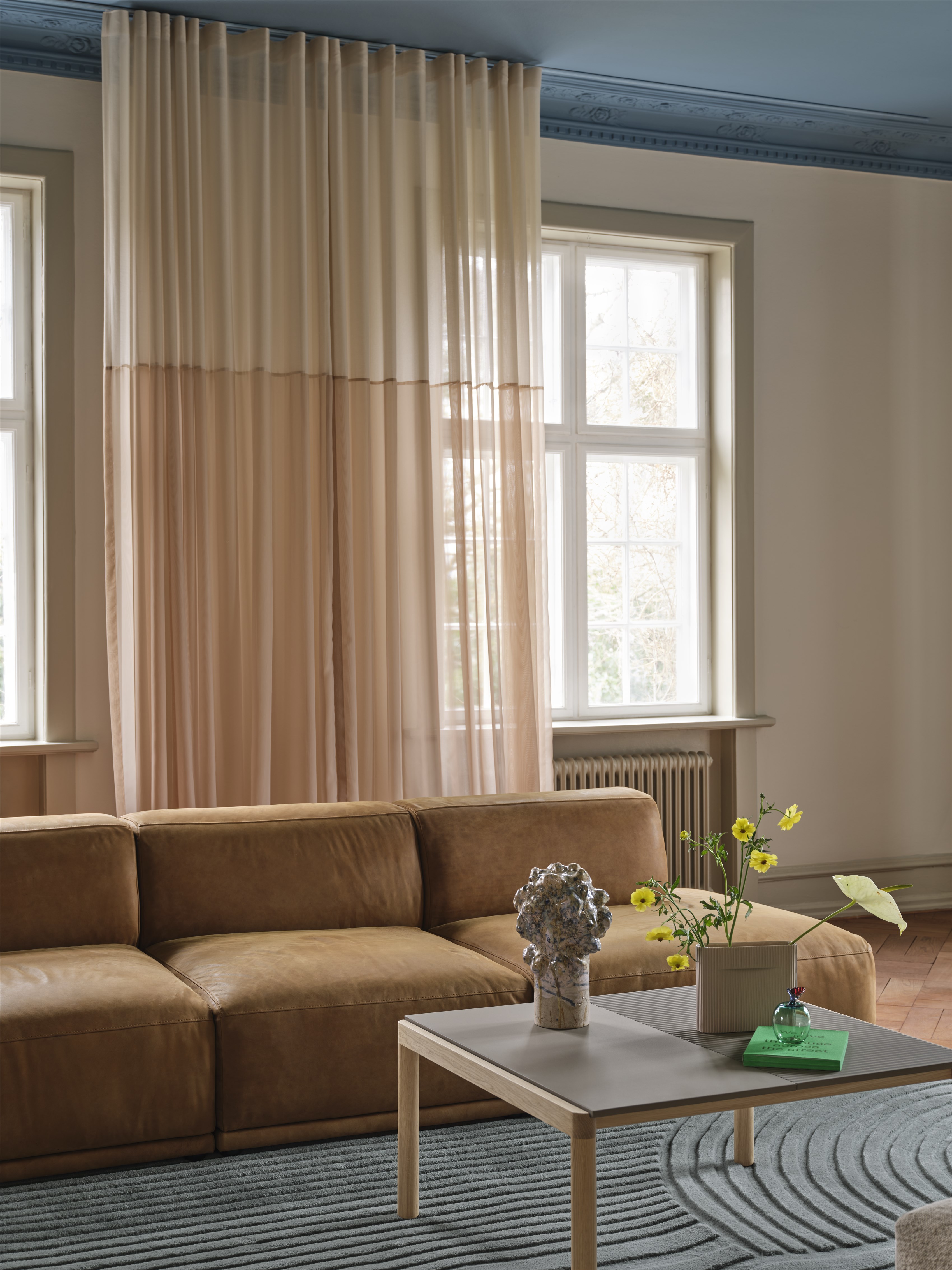 a beige leather sofa in a room with a light blue painted ceiling