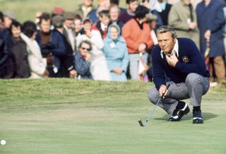 A golfer lines up a putt on the green