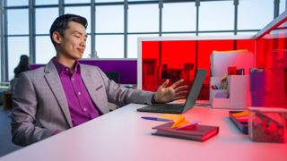 A man working at a desk on a laptop