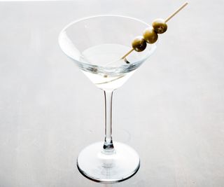 A martini glass with olives in