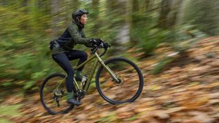 Salsa Cycles Confluence gravel e-adventure bike being ridden in a leafy woodland