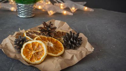 Dried orange slices besides pinecones