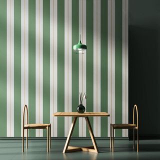 Green and pink striped wallpaper in a dining room set up with a table and chairs in front of the wall