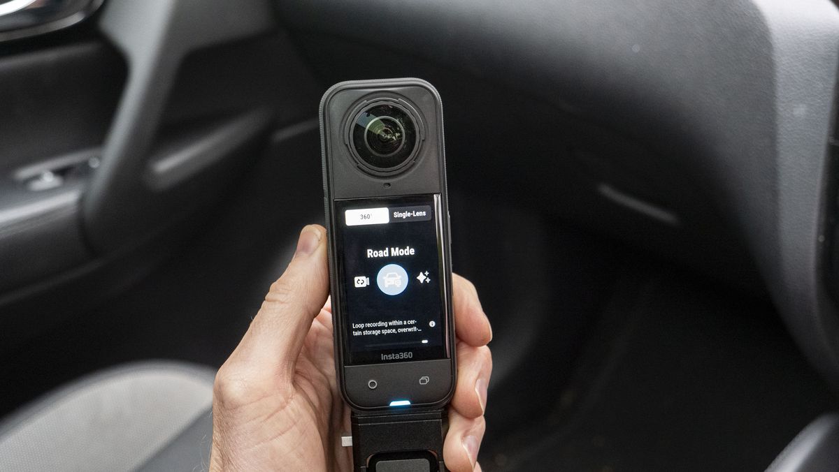 Insta360 X5 inside a car in user's hand, with road mode on the display