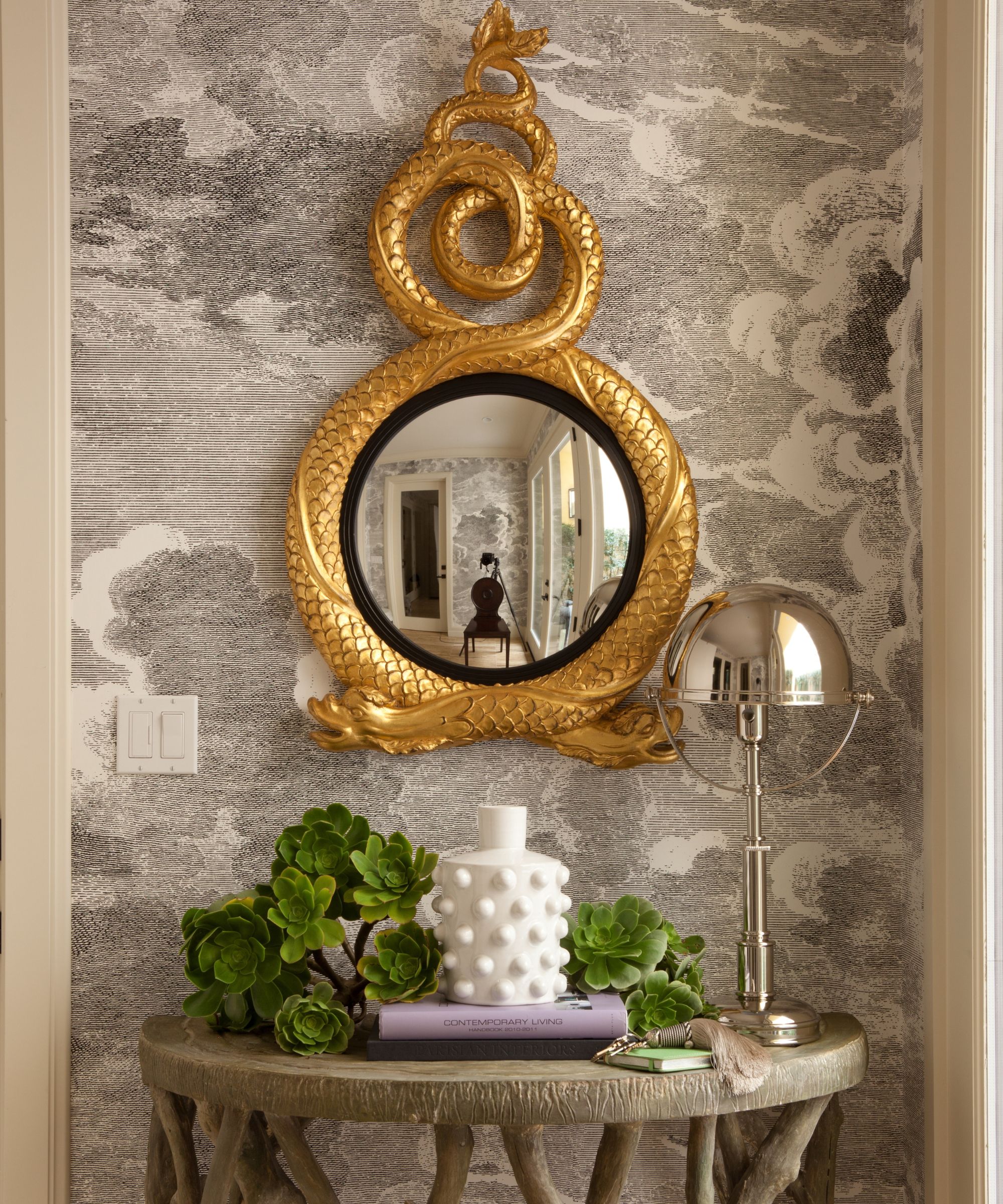 entry with wallpaper and ornate gold mirror