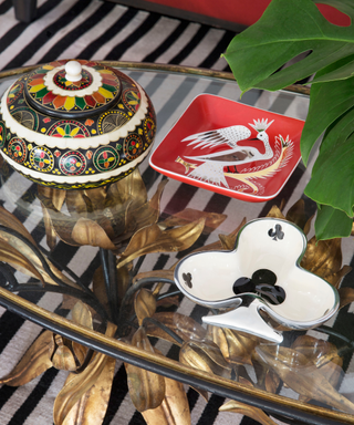 A glass coffee table with bright-colored trinkets.