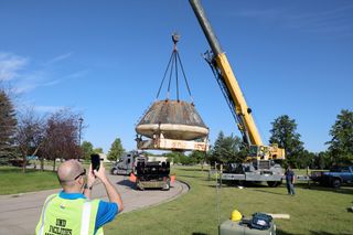 A crane is used to position the Orion crew module at the University of North Dakota's Space Studies Dept.