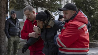 A man injured in the Yavoriv attack is assisted by medical personnel
