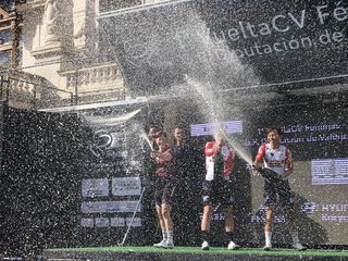 The riders spray the champagne on the podium of the Vuelta a la Comunitat Valenciana Feminas