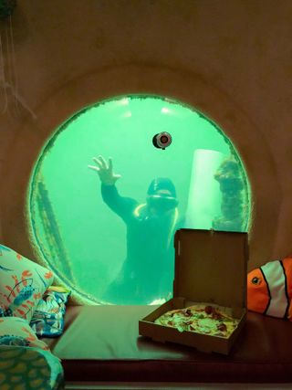 diver at undersea hotel room window