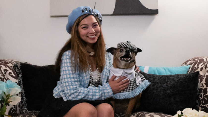 Sarah sitting on the sofa with her dog Duke, both wearing tartan blue outfits